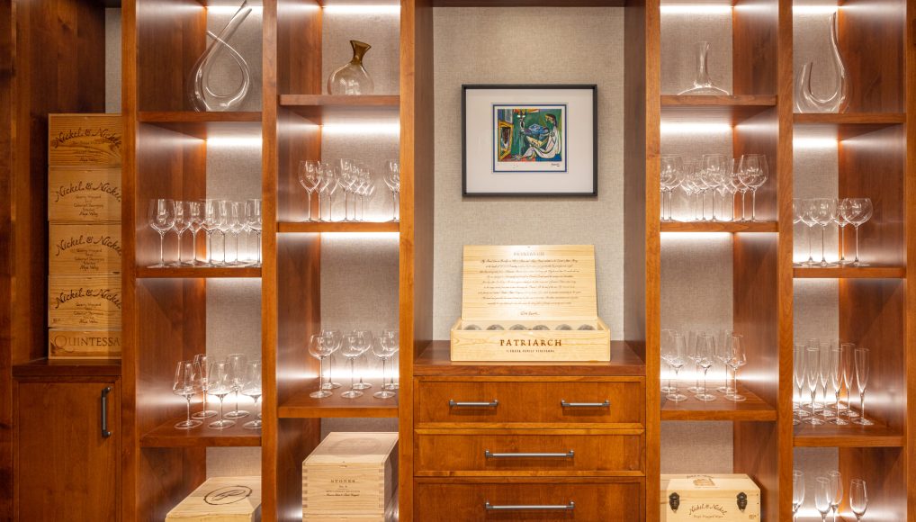 Custom wood shelving featuring cigars and wine glasses in custom new home.